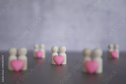 Wooden dolls and pink heart with copy space. Love, romantic, relationship, couple concept