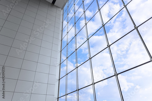 Large windows blue sky of modern business office building in metropolitan. Interior shopping mall glass frame window saving energy lighting design.