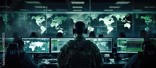 Military personnel, computer experts in office monitoring cybersecurity and control room, Army collaboration on database research.