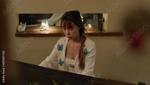 Pretty Asian girls plays piano at home. slow motion. photo