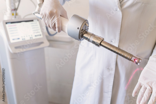 female doctor holds in hands carbon dioxide laser with phallic attachment for vaginal rejuvenation. Hardware cosmetology and medicine. Skin tightening, scar removal, stretch marks and lifting closeup photo