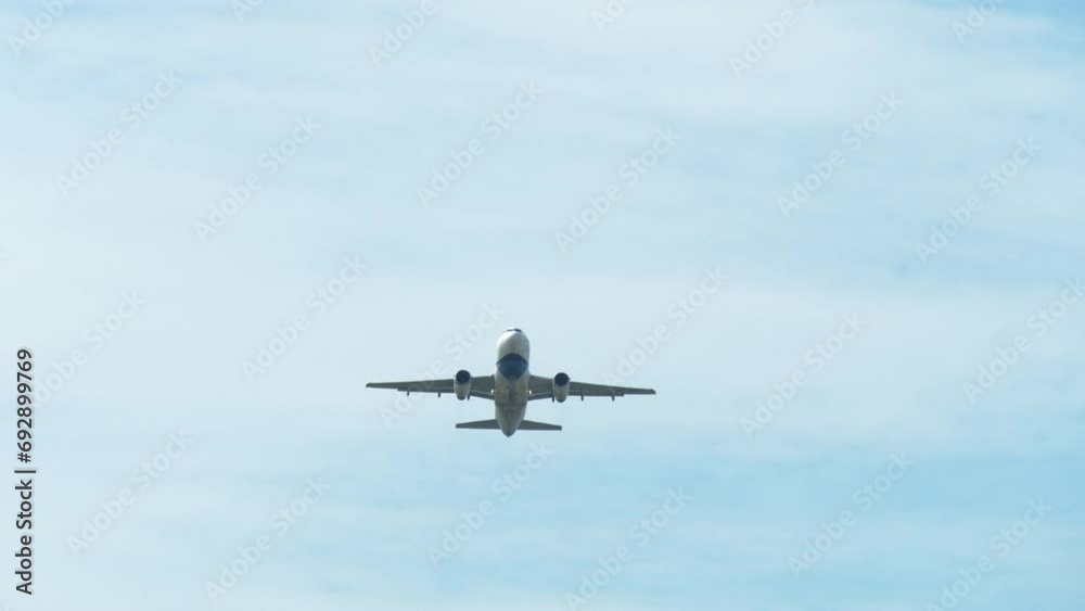 An airplane captured from its underside as it is taking off revealing a blue sky and clouds, airport in Thailand. An airplane captured from its underside as it is taking off revealing a blue sky and clouds, airport in Thailand.
