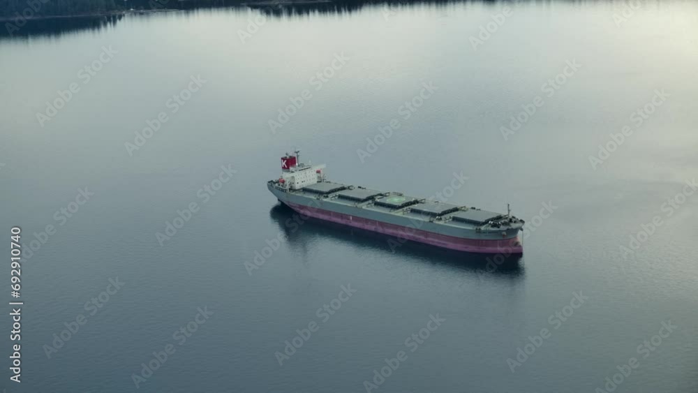 Tranquil View Of A Bulk Carrier Navigating In Waterways During Sunrise. Aerial Drone Shot Tranquil View Of A Bulk Carrier Navigating In Waterways During Sunrise. Aerial Drone Shot