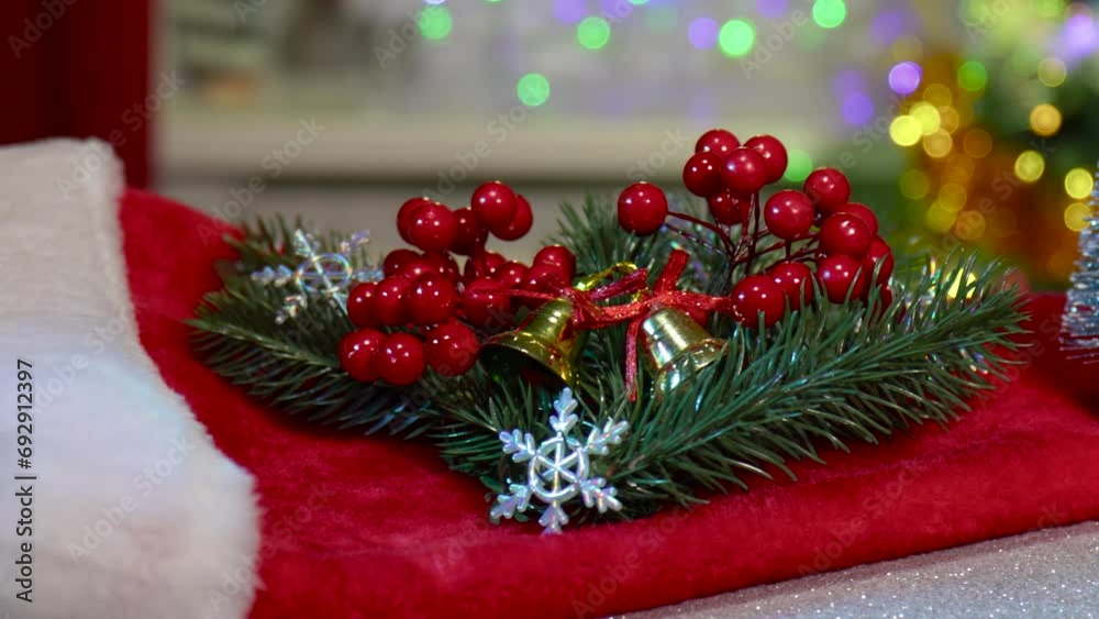 On a semi-blurred background with flashing lights, close-up of Christmas tree branches with berries and a blue Christmas tree On a semi-blurred background with flashing lights, close-up of Christmas tree branches with berries and a blue Christmas tree