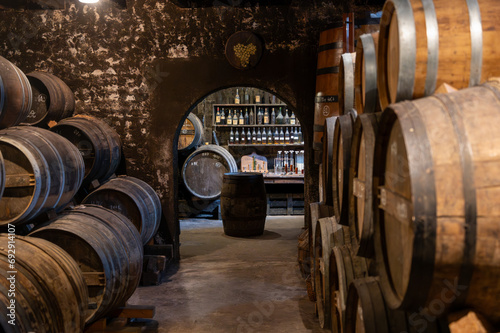 Fotografie Aging process of cognac spirit in old French oak barrels in cellar in distillery