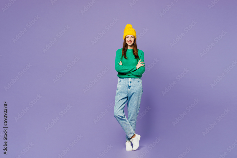 Full body smiling young woman she wear green sweater yellow hat casual clothes hold hands crossed folded look camera isolated on plain pastel light purple background studio portrait Lifestyle concept Full body smiling young woman she wear green sweater yellow hat casual clothes hold hands crossed folded look camera isolated on plain pastel light purple background studio portrait Lifestyle concept