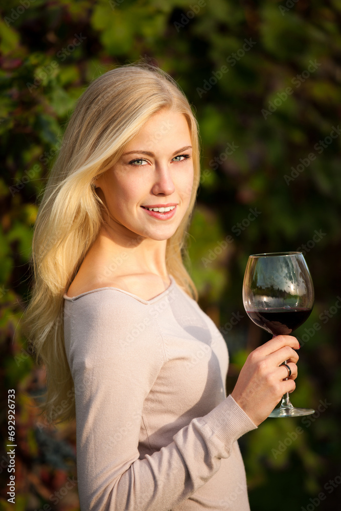 Woman drinks red wine in vineyard Woman drinks red wine in vineyard
