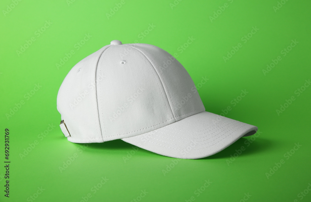 Fototapeta premium Stylish white baseball cap on light green background