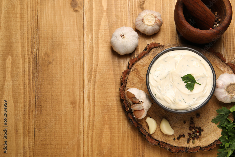 Tasty sauce with garlic, spices and parsley on wooden table, flat lay. Space for text Tasty sauce with garlic, spices and parsley on wooden table, flat lay. Space for text