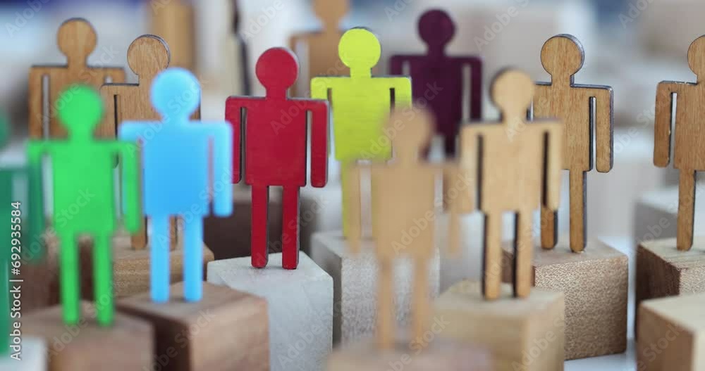 Multi-colored wooden figurines of people in crowd of figurines. Self-esteem and environment concept Multi-colored wooden figurines of people in crowd of figurines. Self-esteem and environment concept