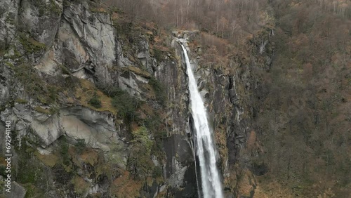 Snow falling in front of a cascading Cascata di Foroglio Waterfall, located in Cavergno village in the district of Vallemaggia in the canton of Ticino, in Switzerland. photo