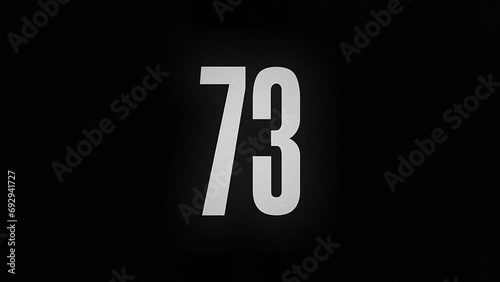 The number 73 smolders and burns on a black background, the number is on fire photo