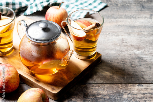 Autumn hot apple drink with spices on wooden table. Copy space