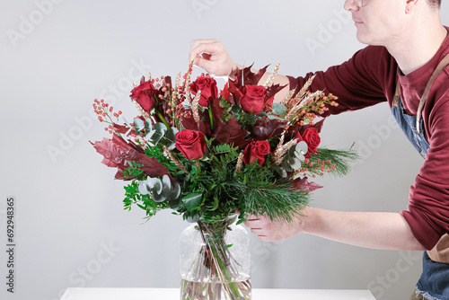 Florista con ramo de flores navideño rojas  photo