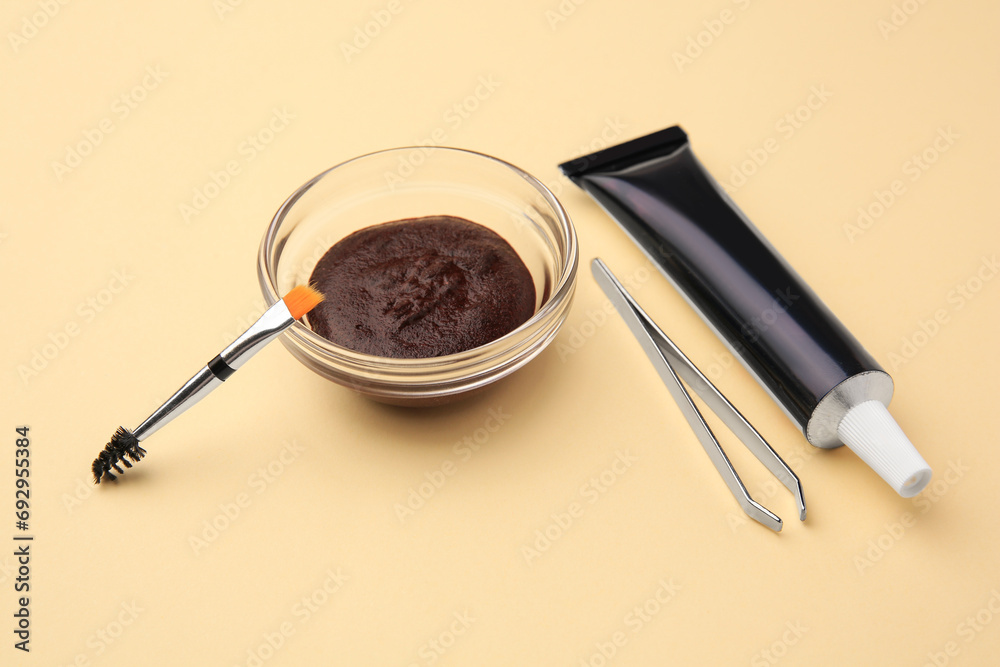Eyebrow henna and tools on beige background