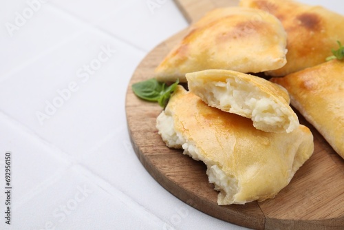 Foto Delicious samosas and basil on white tiled table, closeup