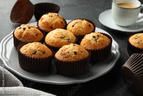 Delicious freshly baked muffins with chocolate chips on table, closeup