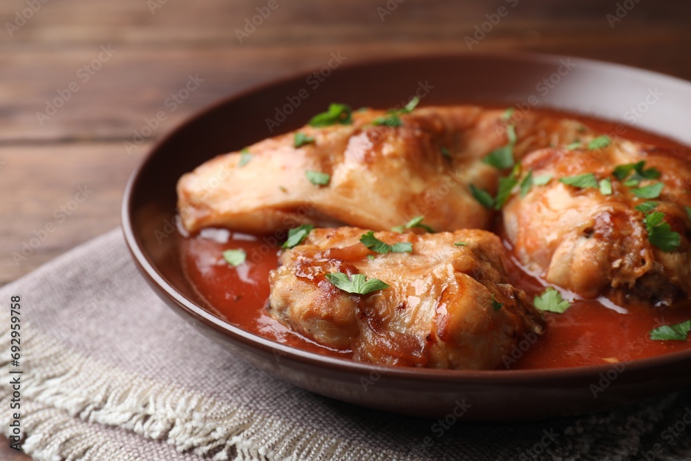Tasty cooked rabbit meat with sauce and parsley on table, closeup Tasty cooked rabbit meat with sauce and parsley on table, closeup