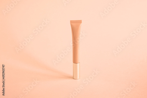 one tall narrow tube for cosmetics lip gloss, cream, on background color of year 2024 peach fuzz