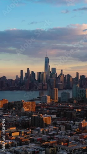 Lower Manhattan, Jersey City and Hudson River. New York at Sunset. Sunlight on Buildings. Aerial View. United States of America. Drone Flies Sideways and Upwards. Vertical Video photo