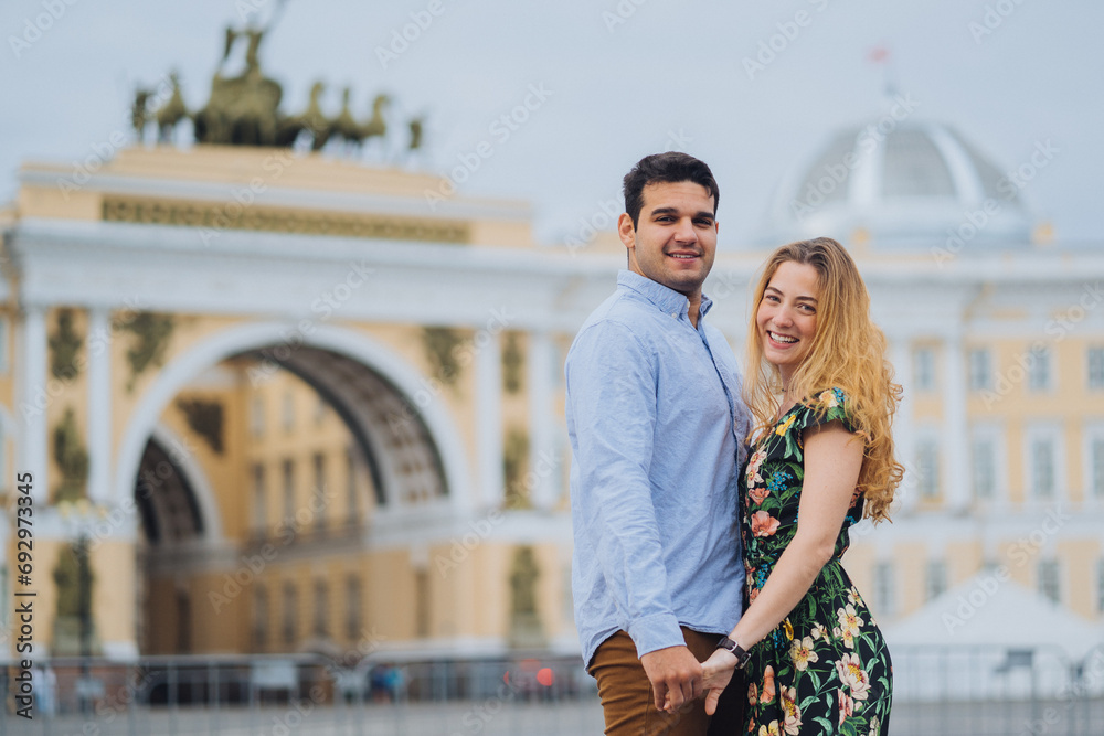 Happy couple embracing in front of an iconic archway, love and travel. Romance, newlyweds at honeymoon...