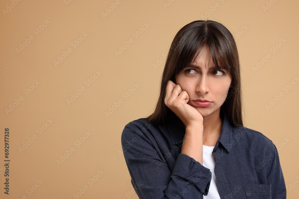 Resentful woman on beige background, space for text Resentful woman on beige background, space for text