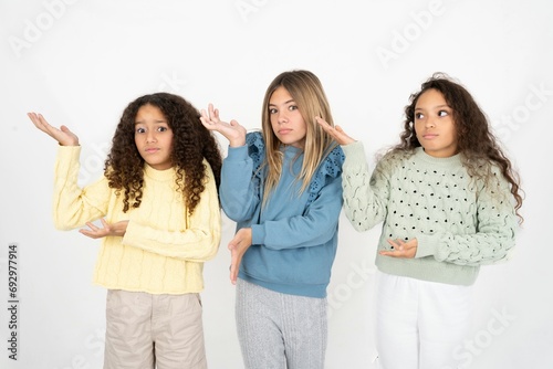 multi racial group of girl friends pointing aside with both hands showing something strange and saying  I don t know what is this. Advertisement concept.