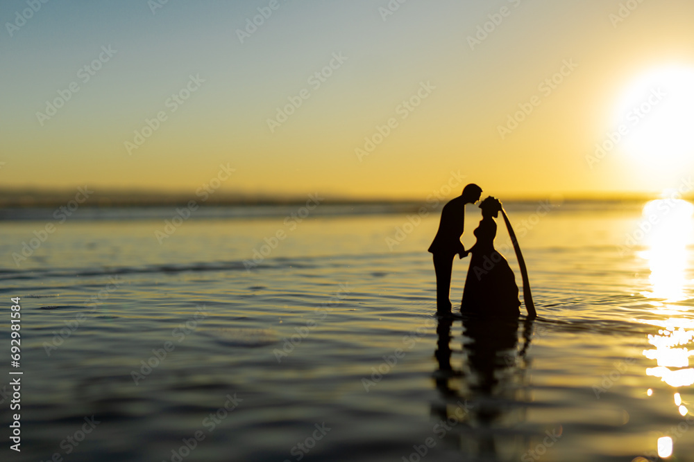 Fototapeta premium 夕日の海と新郎新婦