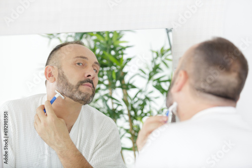 the man shaves his face