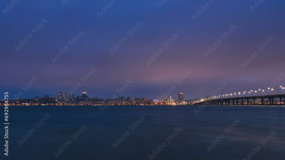Night big city. Panoramic view of the towers, skyscrapers, promenade in the evening, the lights are reflected on the Dnieper River, Ukraine. Dnipro city. spring, autumn, summer.