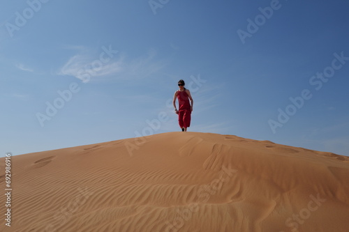 Woman in red dress on sand dunes