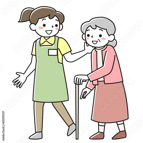 杖をついて歩くシニア女性と付き添う介護職員