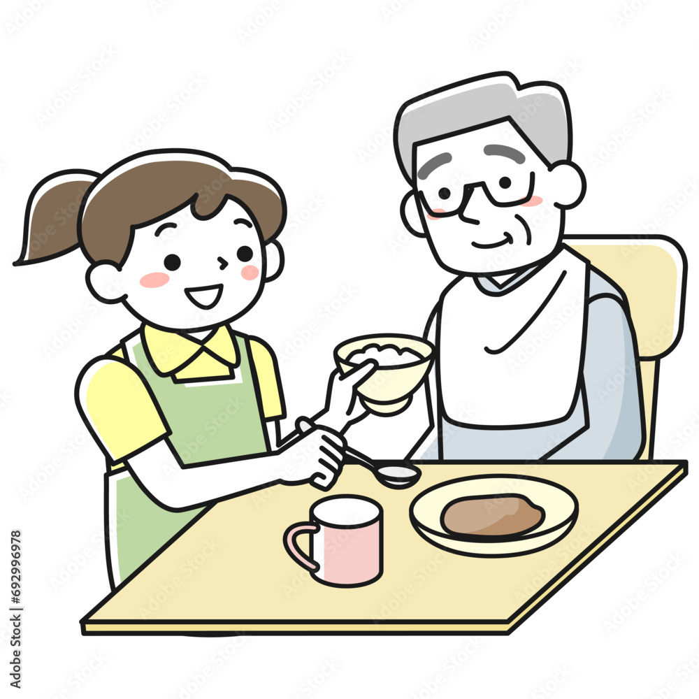 座って食事をするシニア男性と介助する女性職員 座って食事をするシニア男性と介助する女性職員
