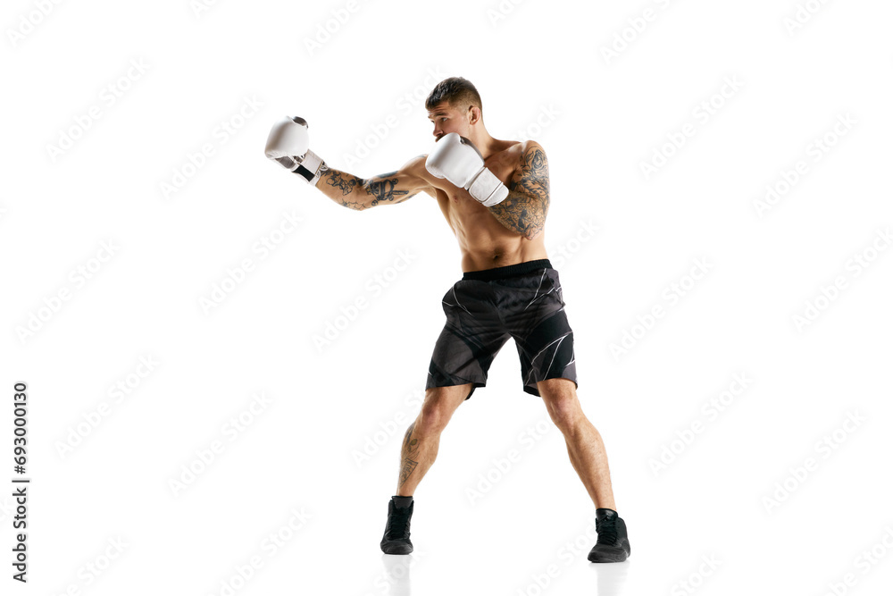 Muscular strong athletic young guy, athlete training, boxing isolated over white background. Strong hands. Concept of professional sport, combat sport, martial arts, strength