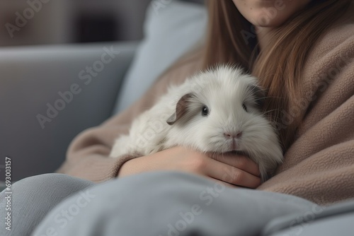 a woman in neutral color cosy sweater sitting in the armchair with a cute guinea pig cuddling in her lap, cosy vibes, close up macro detail © World of AI