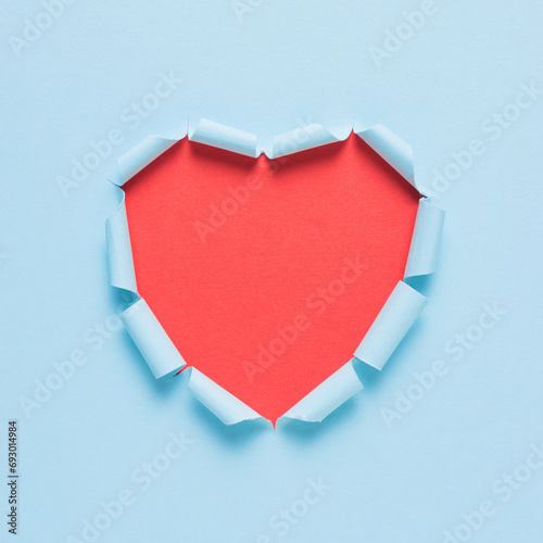 Vivid torn paper heart on bright background. Minimal love or lik
