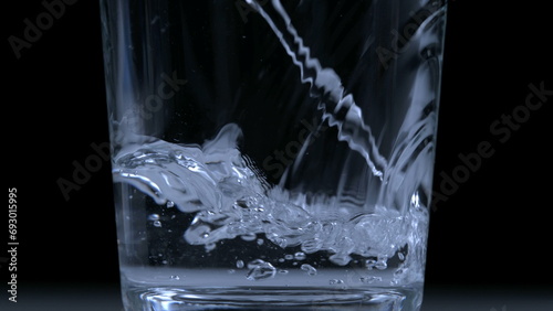 Pouring water into glass cup in ultra slow-motion at 1000 fps captured with high-speed camera
