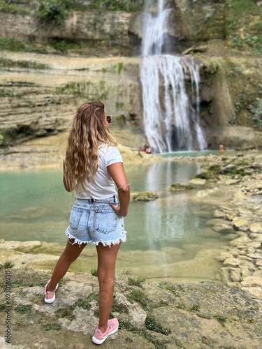 Young pretty girl wachting an amazing waterfall in Bohol island  Philippines. High quality photo