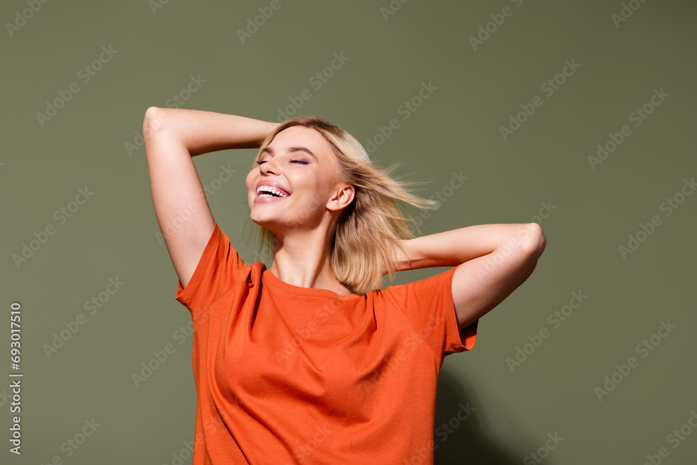 Photo portrait of attractive young woman touch head new hairdo cosmetics dressed stylish orange garment isolated on khaki color background Photo portrait of attractive young woman touch head new hairdo cosmetics dressed stylish orange garment isolated on khaki color background