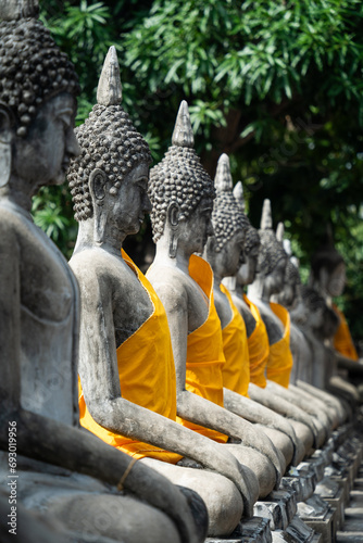 Statues de bouddha dans un temple Thaïlandais, avec des étoffes jaune orange