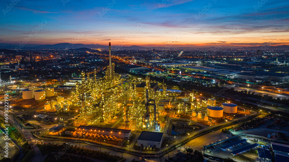 Fototapeta premium Aerial view of the morning of the oil refinery from the drone of the tower of the Petrochemistry industry in the oil​ and​ gas​ ​industry with​ cloud​ sun orange​