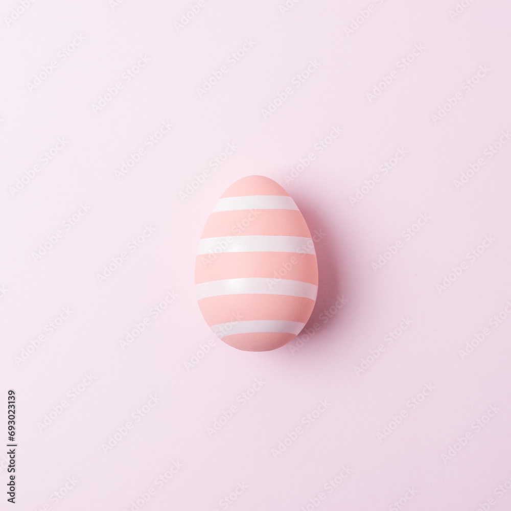 Colorful Easter egg on pink background. Minimal Easter concept. Flat lay.
