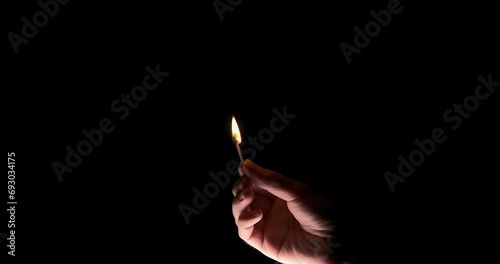 Lighting a match in hand on a black background
