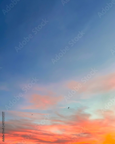Sunset sky with colorful clouds vertical background concept. Evening sunset. Dusk sky view. Dramatic red, orange and yellow twilight sky.