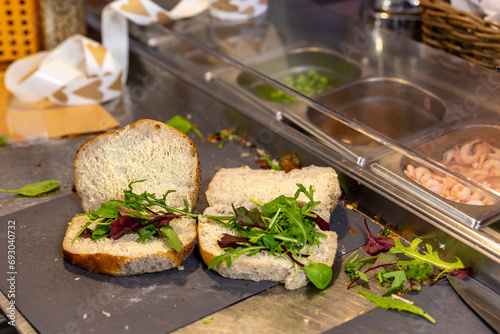 Stockholm, Sweden Sandwiches get made inside a cafe on a stainless counter. photo