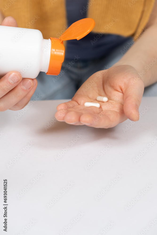 A woman pours capsules out of a jar. Medicines and medicine A woman pours capsules out of a jar. Medicines and medicine
