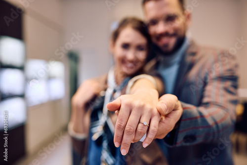 Close up of couple engagement buying ring at jewelry store photo