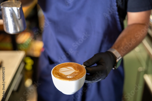 Stockholm, Sweden A barista in a coffee shop mixes a cappuccino photo