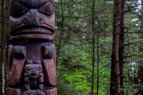 Tlingit totem poles and lush woods tree nature landscape scenery in Sitka Historical Park hiking trails with creeks, green bushes and vegetation in magic fairytale environment Baranof Island