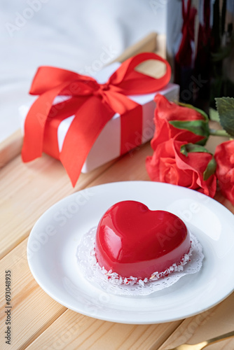 heart shaped glazed valentine cake and flowers on wooden tray